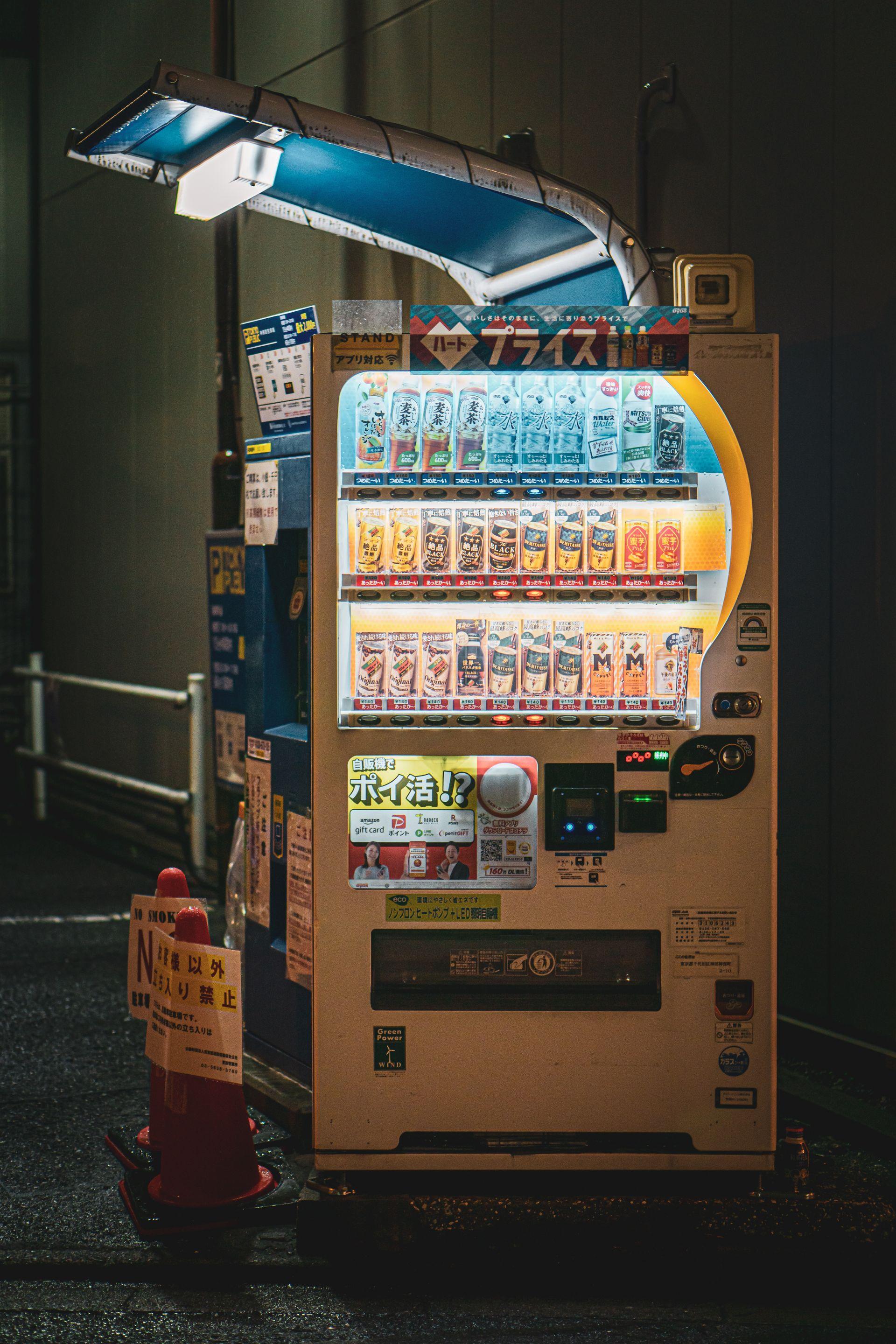 Brightly lit beverage vending machine at night