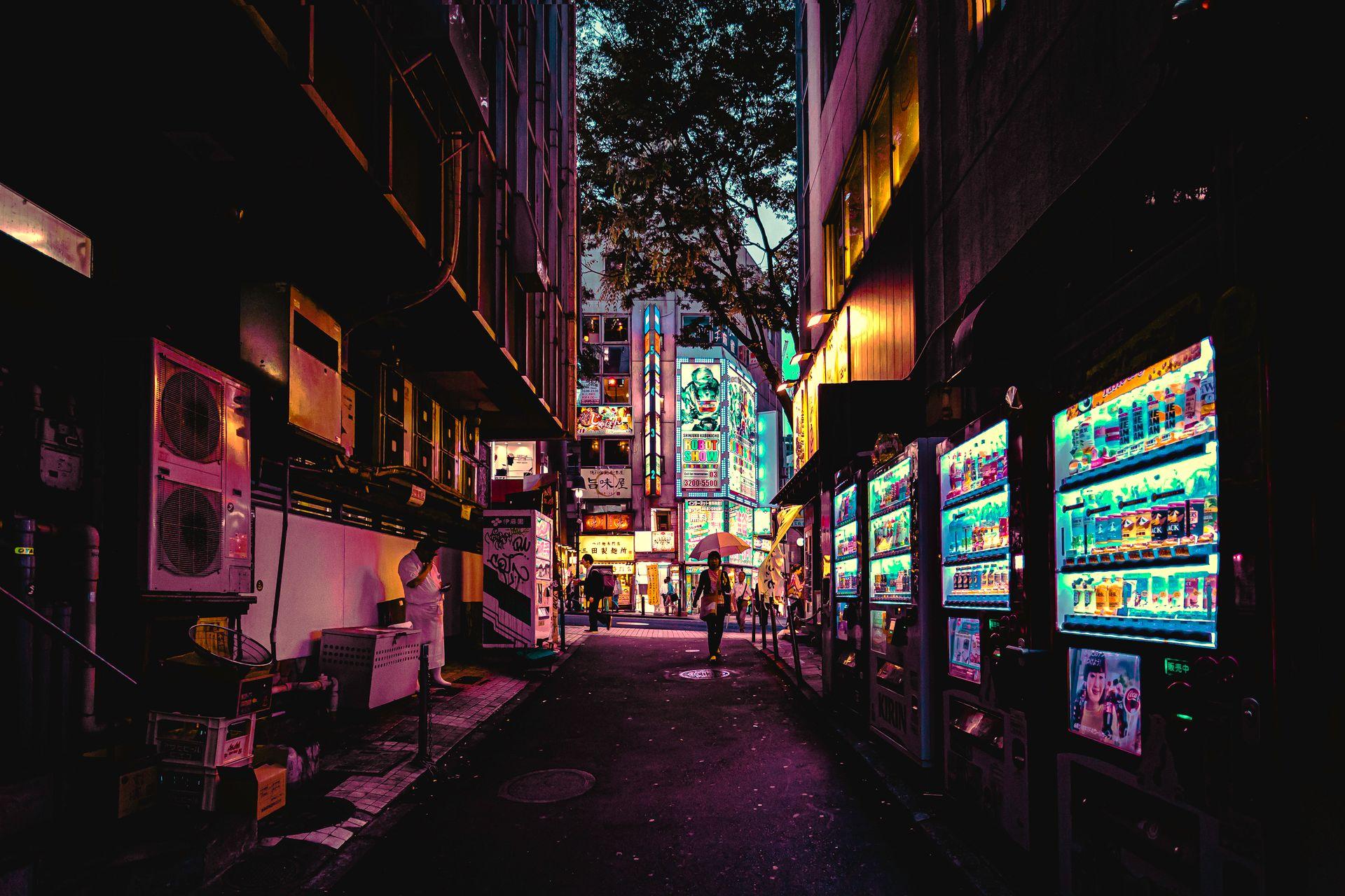 Illuminated vending machines lining a city street at dusk