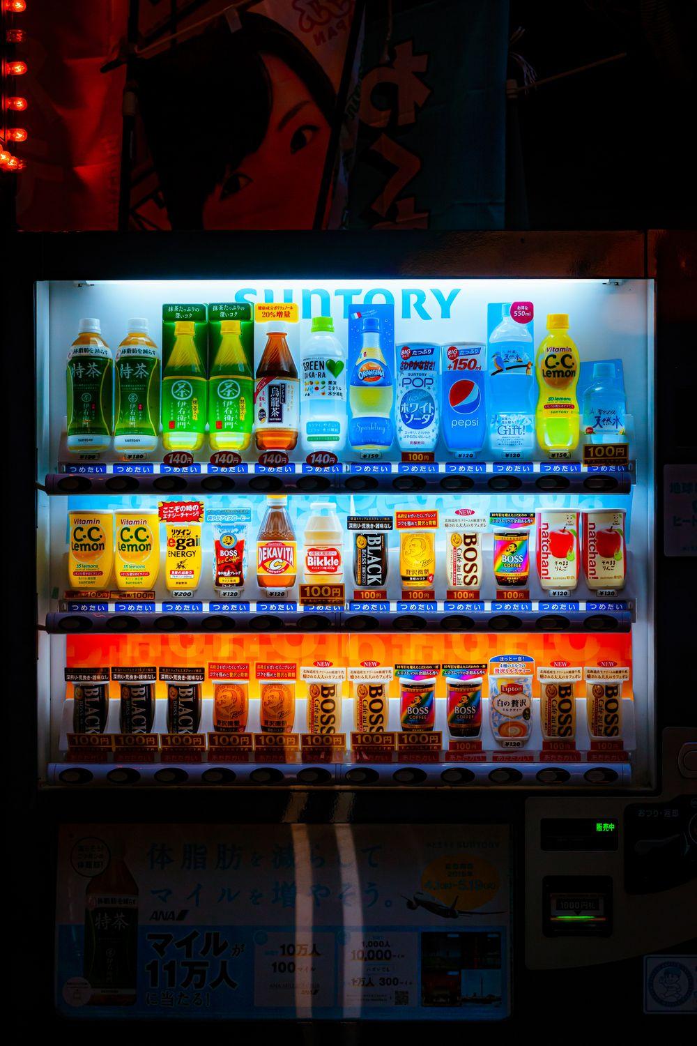 Backlit beverage vending machine shelves at night